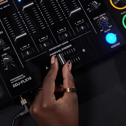 Close-up of a DJ adjusting the MAGVEL crossfader on the Pioneer DDJ-FLX10, with channel faders and effects controls visible.